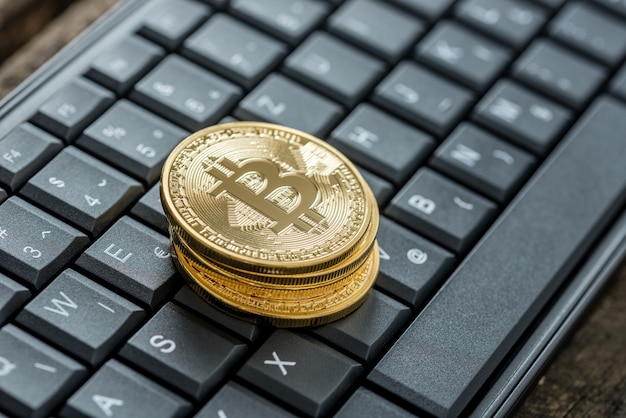 Vista de alto ângulo de quatro bitcoins dourados em um teclado como conceito para moeda e ganhos digitais.