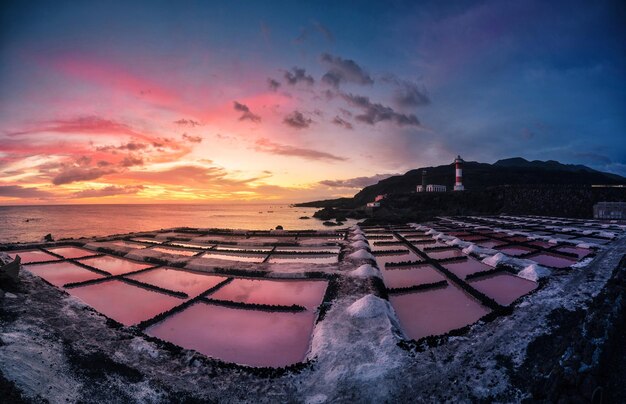 Foto vista de alto ângulo de salinas pelo mar contra o céu nublado durante o pôr-do-sol