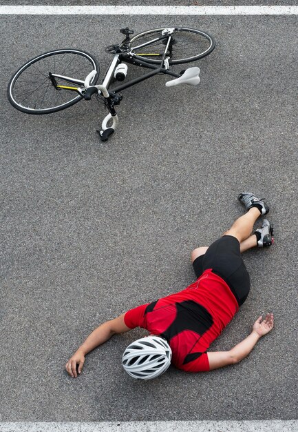 Vista de alto ângulo de um homem caído de bicicleta na estrada