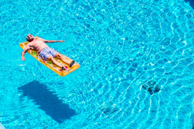 Foto vista de alto ângulo de um homem relaxando na piscina