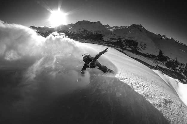 Foto vista de alto ângulo de um homem snowboarding no topo de uma montanha