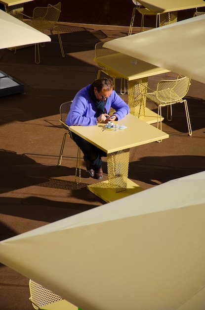 Vista de alto ângulo de um homem usando o telefone em um café na calçada