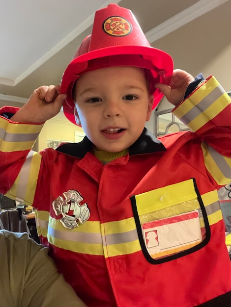 Foto vista de alto ângulo de um menino bonito com tldresed como bombeiro