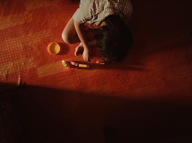 Foto vista de alto ângulo de um menino brincando com brinquedos em casa