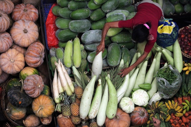 Foto vista de alto ângulo de um vendedor vendendo legumes no mercado