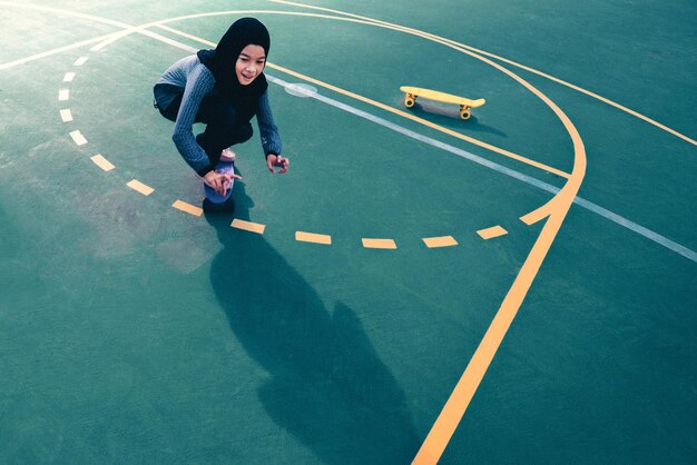 Foto vista de alto ângulo de uma adolescente patinando em uma quadra de basquete