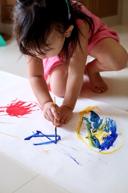 Foto vista de alto ângulo de uma menina pintando no chão