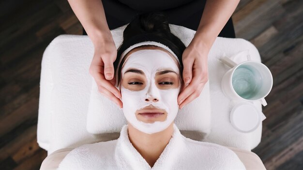 Vista de alto ângulo de uma mulher recebendo máscara facial em um salão de beleza