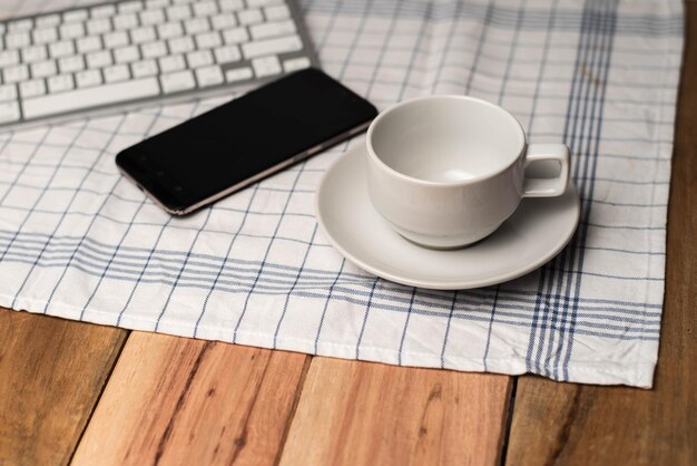 Foto vista de alto ângulo de xícara de café e telefone móvel na mesa