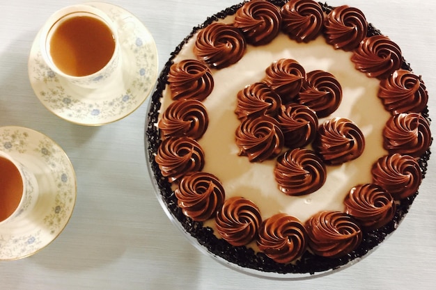 Vista de alto ângulo de xícaras de chá e bolo de chocolate na mesa