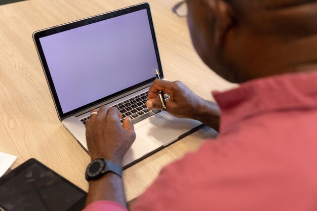 Vista de alto ângulo do empresário afro-americano maduro usando laptop com espaço de cópia na tela em branco