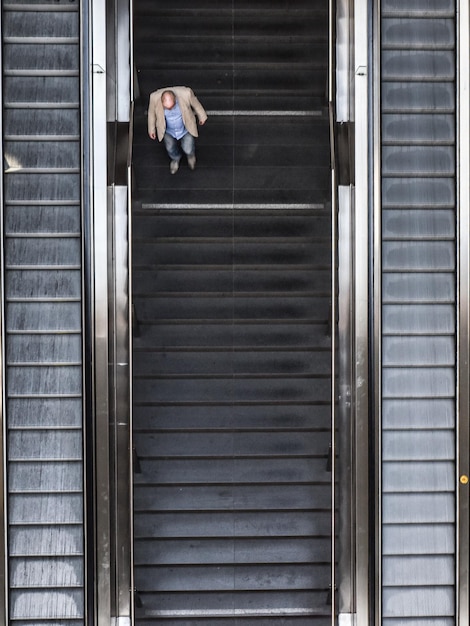 Foto vista de alto ângulo do homem na escada rolante