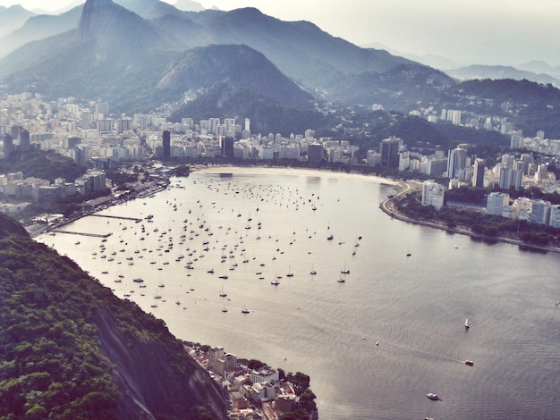 Vista de alto ângulo do mar pela cidade contra as montanhas