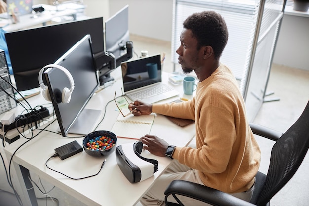 Vista de alto ângulo do programador afro-americano desenvolvendo software no escritório