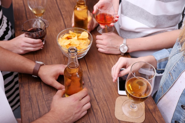 Vista de amigos tomando bebidas alcoólicas no bar de perto