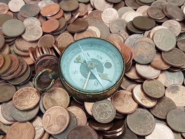 Vista de ângulo alto da bússola de navegação em moedas