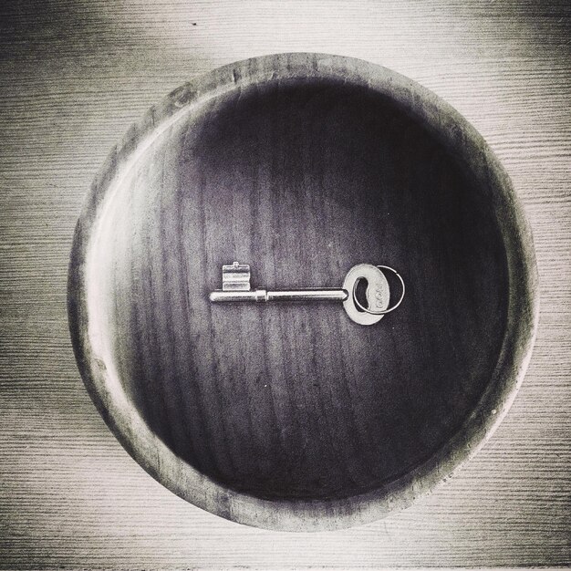 Foto vista de ângulo alto da chave em uma tigela de madeira na mesa