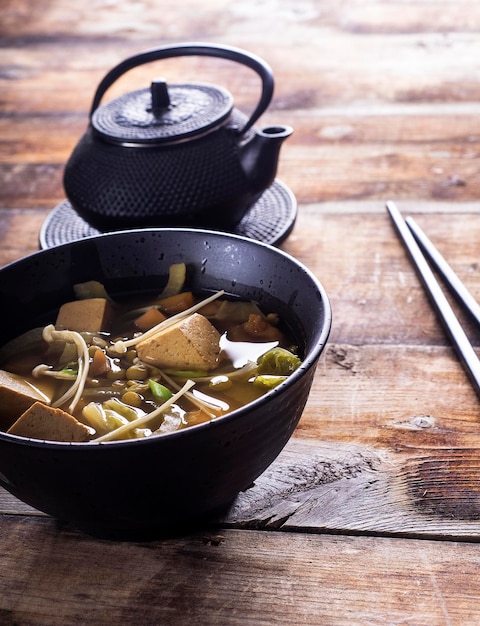 Vista de ângulo alto da sopa de tofu pela chaleira na mesa