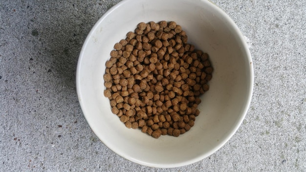 Vista de ângulo alto de alimentos para animais em uma tigela na mesa