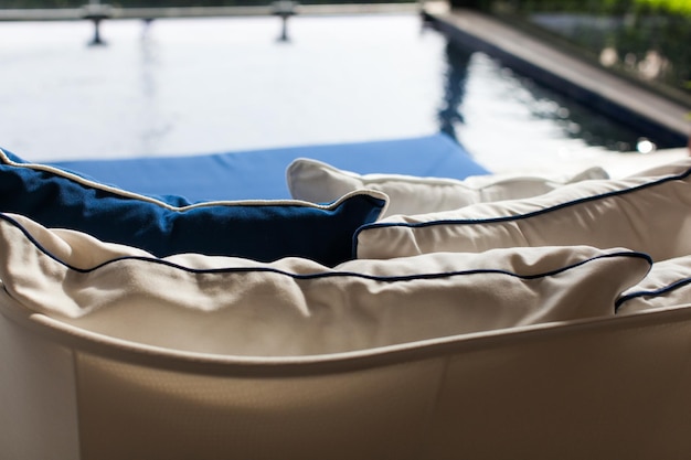 Foto vista de ângulo alto de almofadas no sofá à beira da piscina