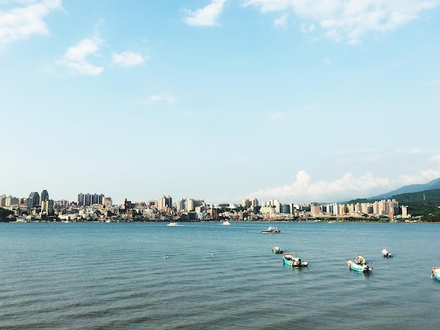 Vista de ângulo alto de barcos no mar por cidade contra o céu