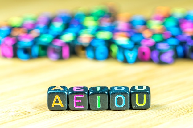 Vista de ângulo alto de blocos de brinquedo com texto aeiou na mesa