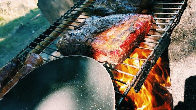Vista de ângulo alto de carne e panela de cozinha em churrasco