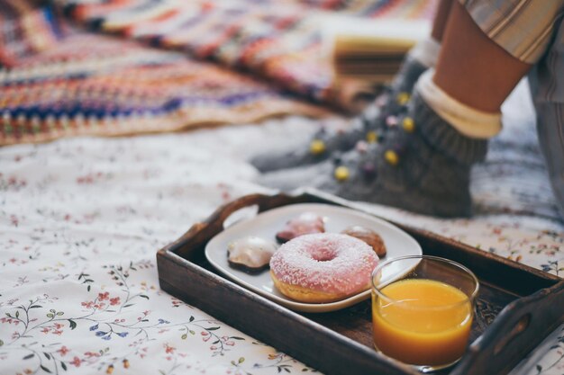 Foto vista de ângulo alto de donuts com suco na cama