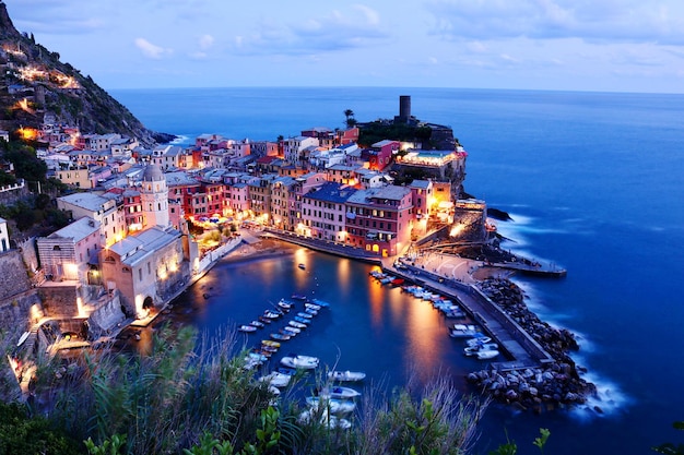 Vista de ângulo alto de edifícios iluminados na cidade pelo mar
