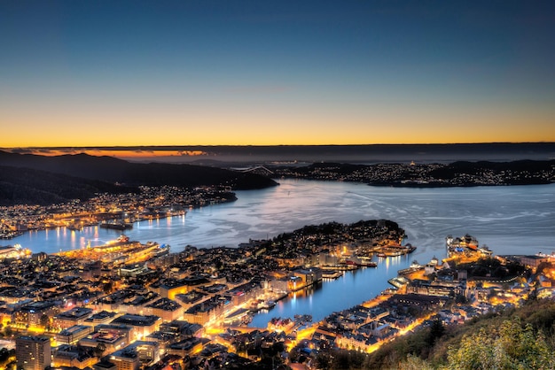 Vista de ângulo alto de edifícios pelo lago contra o céu claro durante o pôr-do-sol