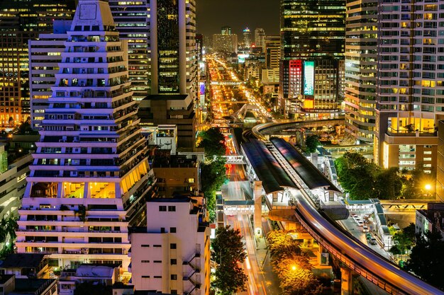 Vista de ângulo alto de estrada iluminada em meio a edifícios à noite