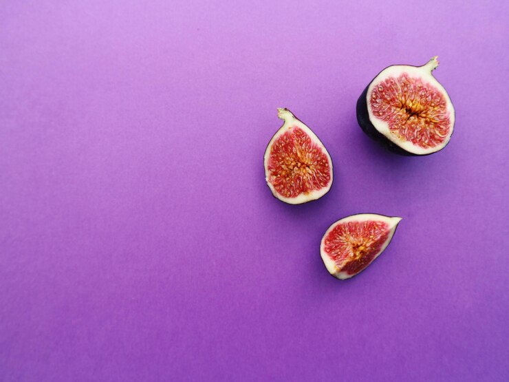 Foto vista de ângulo alto de frutas contra fundo roxo.