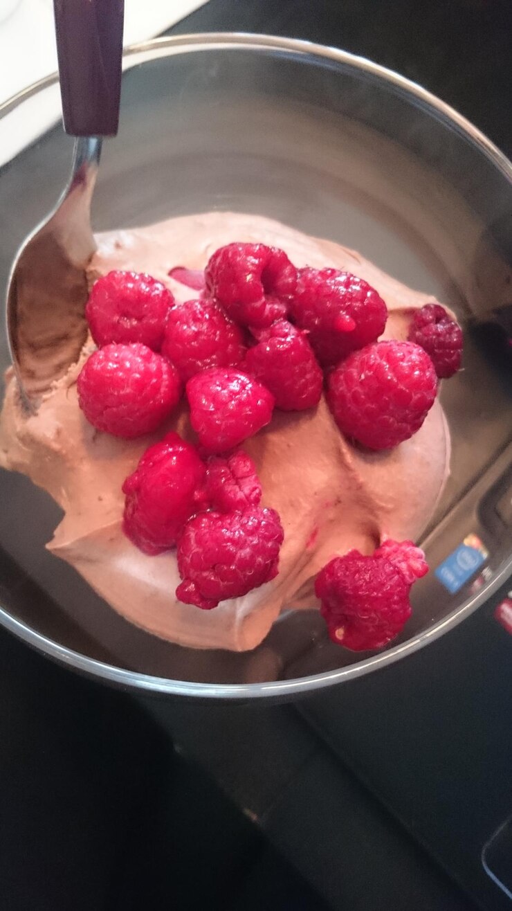 Foto vista de ângulo alto de frutas de framboesa frescas com mousse de chocolate em uma tigela