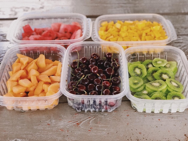 Vista de ângulo alto de frutas em recipientes sobre a mesa