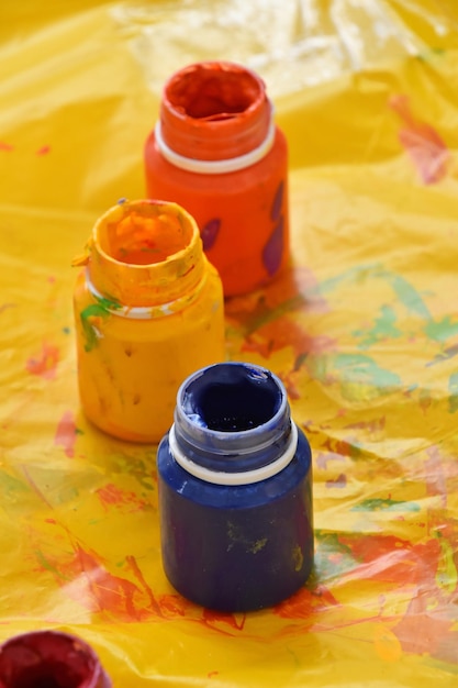 Foto vista de ângulo alto de garrafas de tinta em papel amarelo bagunçado