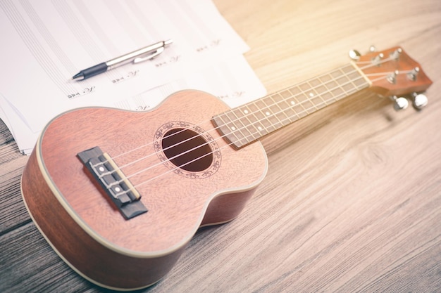 Foto vista de ângulo alto de guitarra com caneta e nota musical na mesa