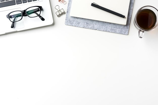 Vista de ângulo alto de laptop com suprimentos de escritório e café em fundo branco