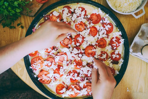 Foto vista de ângulo alto de mãos preparando pizza