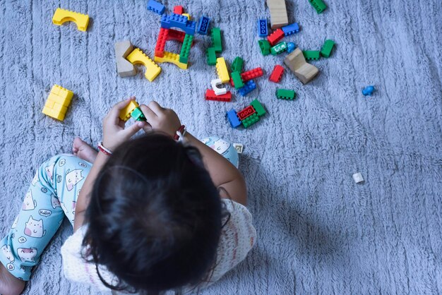 Foto vista de ângulo alto de menina brincando com brinquedos na mesa