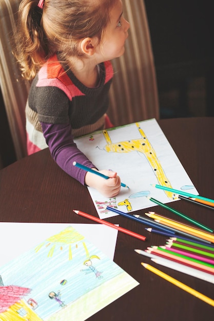 Foto vista de ângulo alto de menina desenhando na mesa