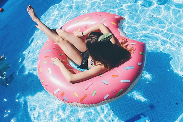 Vista de ângulo alto de mulher em anel inflável na piscina