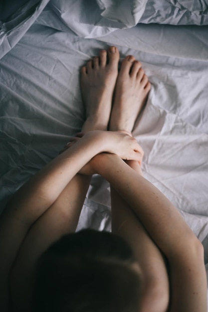 Vista de ângulo alto de mulher sentada na cama em casa