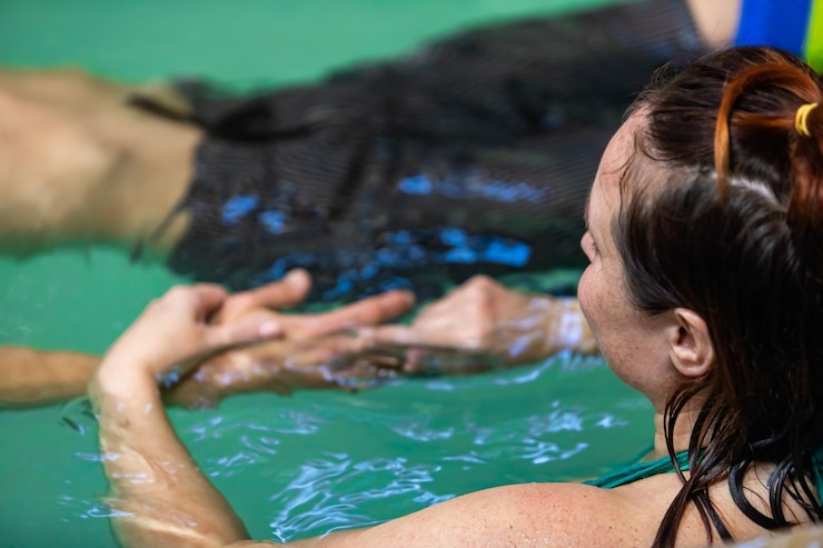 Foto vista de ângulo alto de mulheres de mãos dadas em pé na piscina