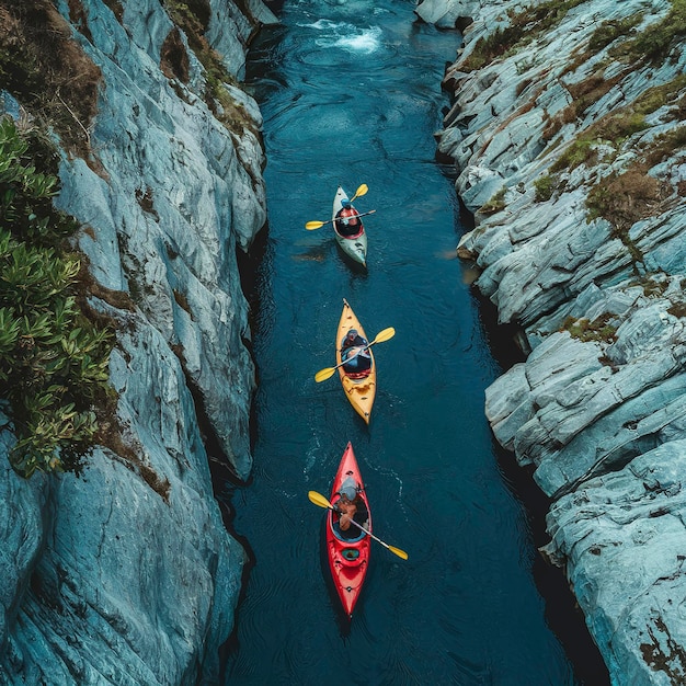 Vista de ângulo alto de pessoas irrecognizáveis fazendo caiaque em um rio estreito azul que flui entre montanhas rochosas