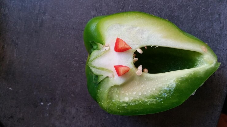Foto vista de ângulo alto de pimenta verde cortada com olhos de segmento de pimenta vermelha
