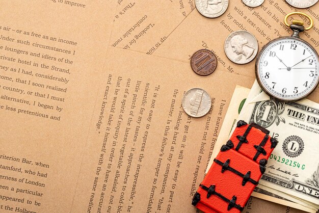 Foto vista de ângulo alto de relógio de bolso com moeda e brinquedo de mala em papel