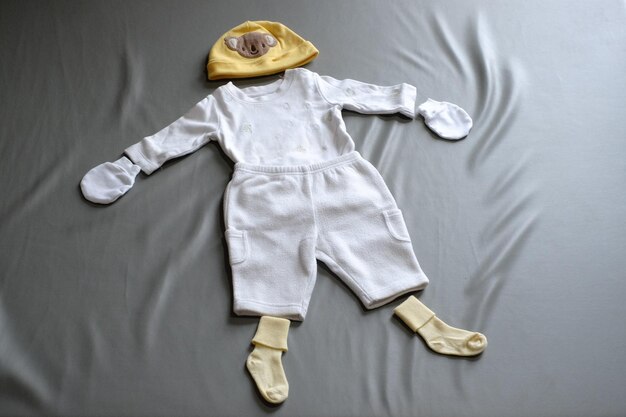 Foto vista de ângulo alto de roupas de bebê na cama em casa