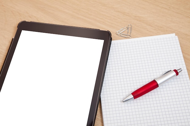 Vista de ângulo alto de tablet digital e bloco de notas em branco na mesa
