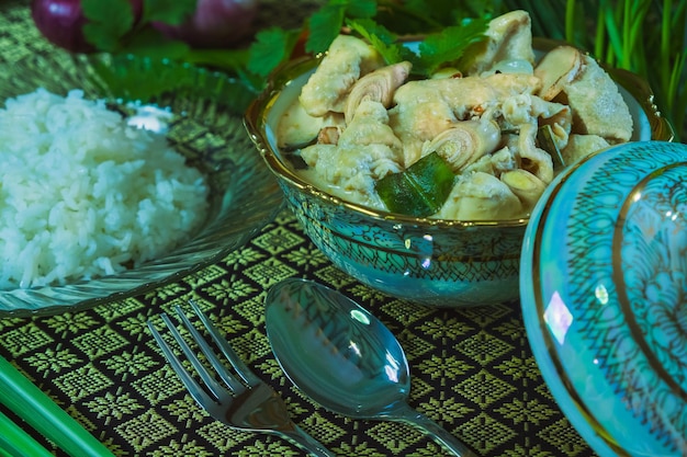 Foto vista de ângulo alto de tom kha gai ou sopa de coco de frango tailandês e arroz em recipiente na mesa