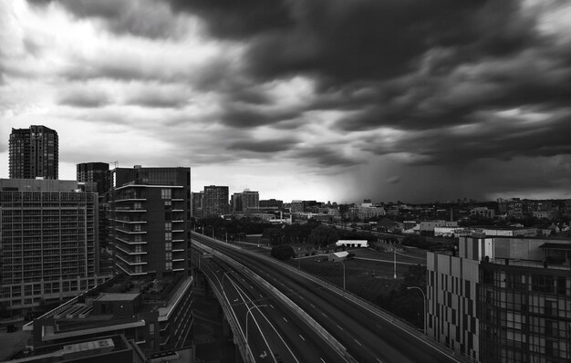 Foto vista de ângulo alto de trilhos de trem por edifícios na cidade contra o céu